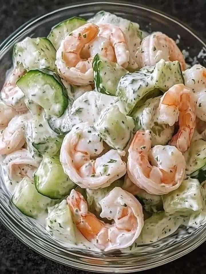 Fresh and creamy crab salad served in a bowl, garnished with lettuce, herbs, and lemon slices.